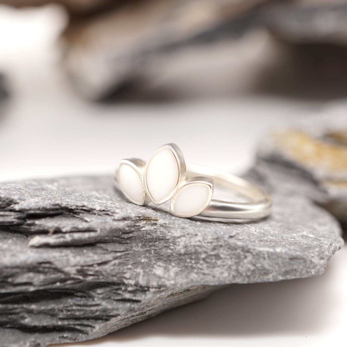 Close-up of Petal Keepsake Ring showcasing its sleek sterling silver band and bold three-petal design with unique semen inlays.