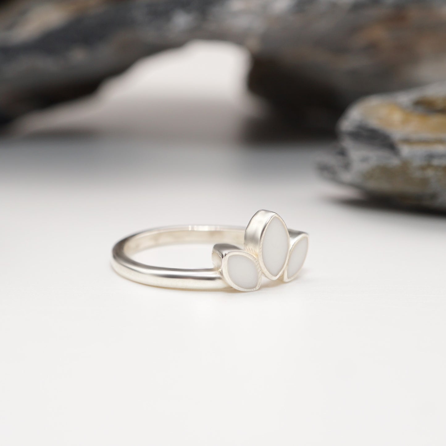 Side view of Petal Keepsake Ring in sterling silver, highlighting its smooth finish and intricate petal-inspired design with custom inlays.