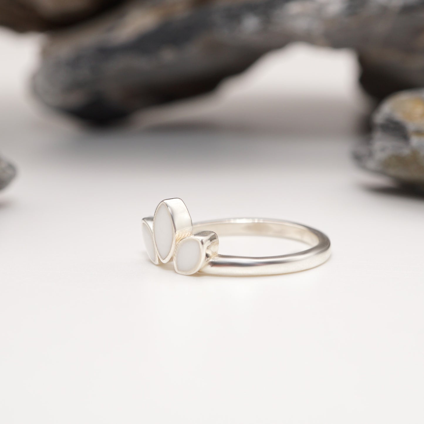 Zoomed-in shot of Petal Keepsake Ring featuring its three-petal design, polished sterling silver finish, and personal semen inlays.