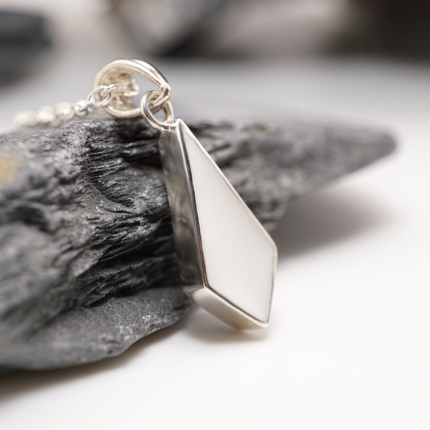 Close-up of Diamond Keepsake Pendant showcasing its sharp geometric design and sleek semen inlay.