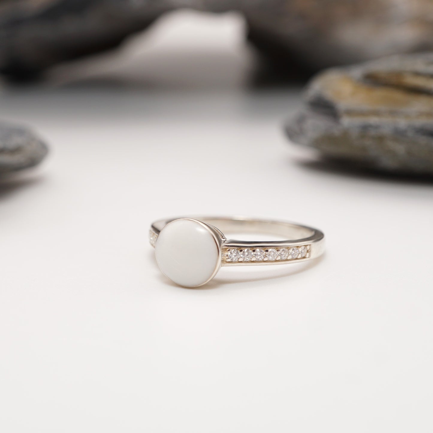 Crown Keepsake Ring in sterling silver with bold semen inlay and pavé accents, displayed elegantly on a natural stone backdrop."
