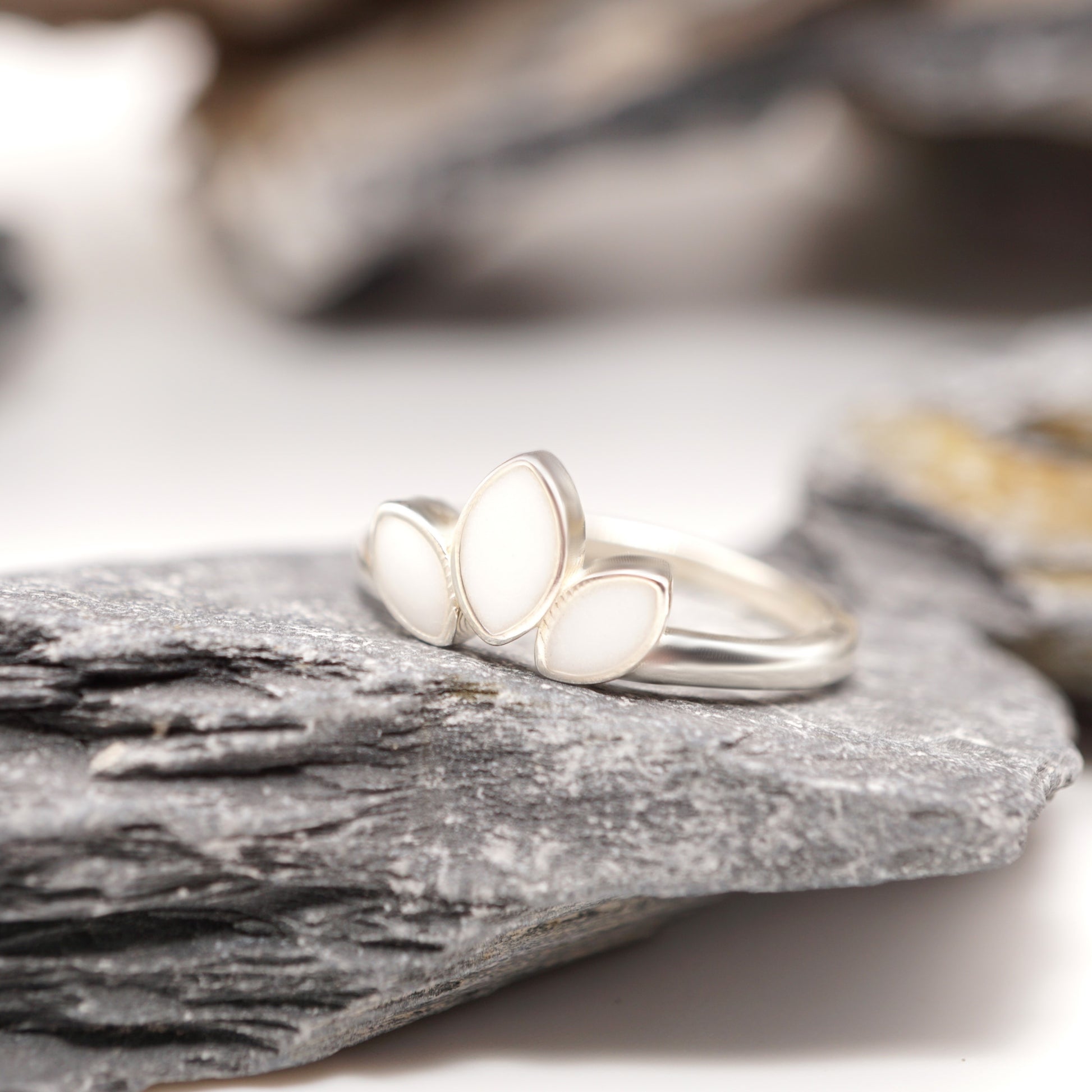 Close-up of Petal Keepsake Ring showcasing its sleek sterling silver band and bold three-petal design with unique semen inlays.
