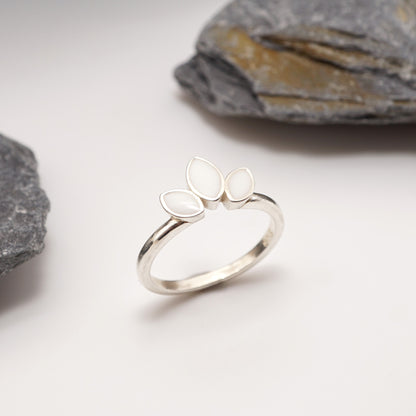 Sterling silver Petal Keepsake Ring with semen inlays, displayed against a natural stone backdrop for a timeless and bold jewellery aesthetic.