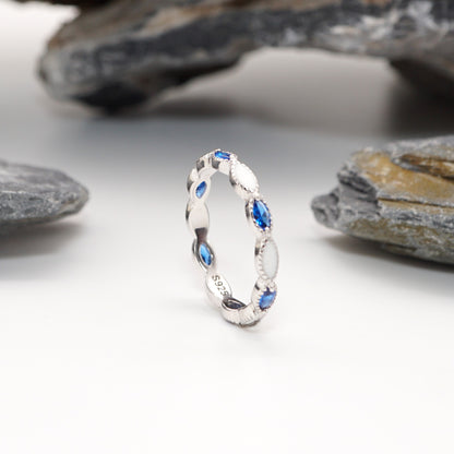 Side view of Eternity Keepsake Ring in sterling silver with intricate milgrain beading, alternating inlays, and marquise-cut blue CZ stones."

